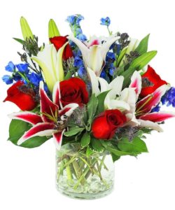 This trendy low and compact vase arrangement is custom designed with fragrant lilies, roses and delphinium. 