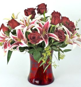 Low and compact European design features romantic red roses and fragrant stargazer lilies