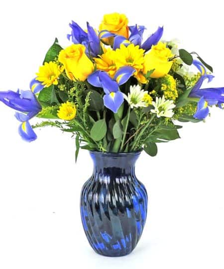 Blue iris, aster and gold roses & chrysanthemums in a blue cobalt glass vase. Measures 18" high.